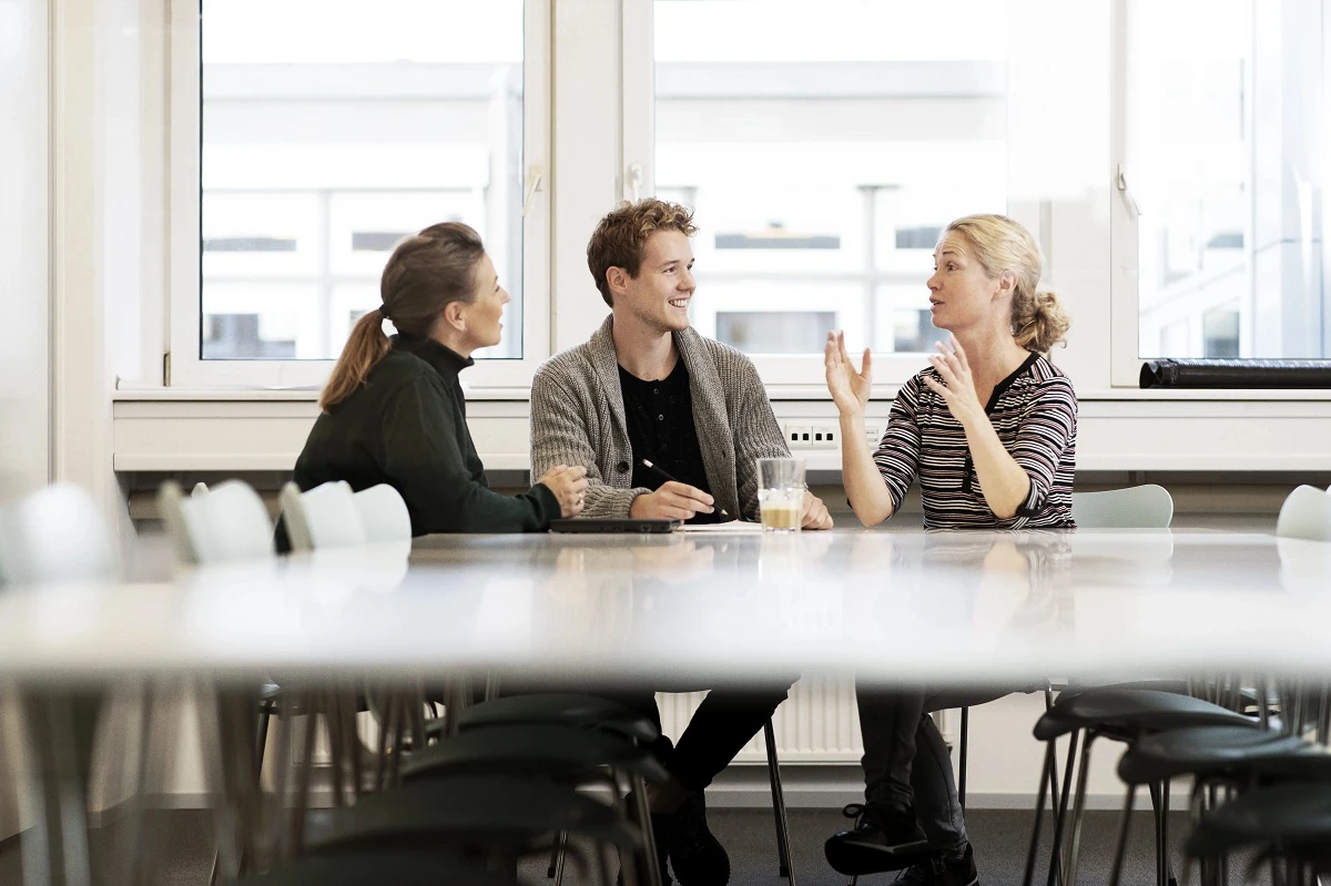 Tre medarbejdere taler på et kontor
