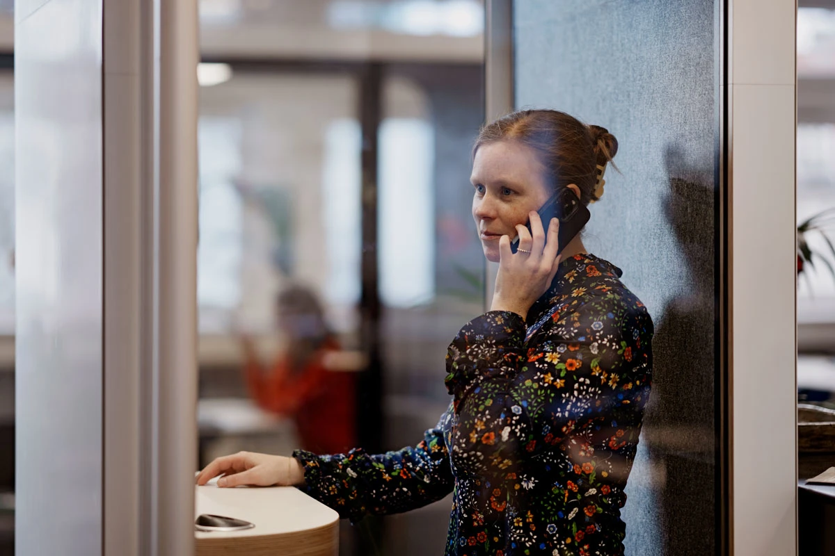 Kvinde har en telefonsamtale på et kontor.