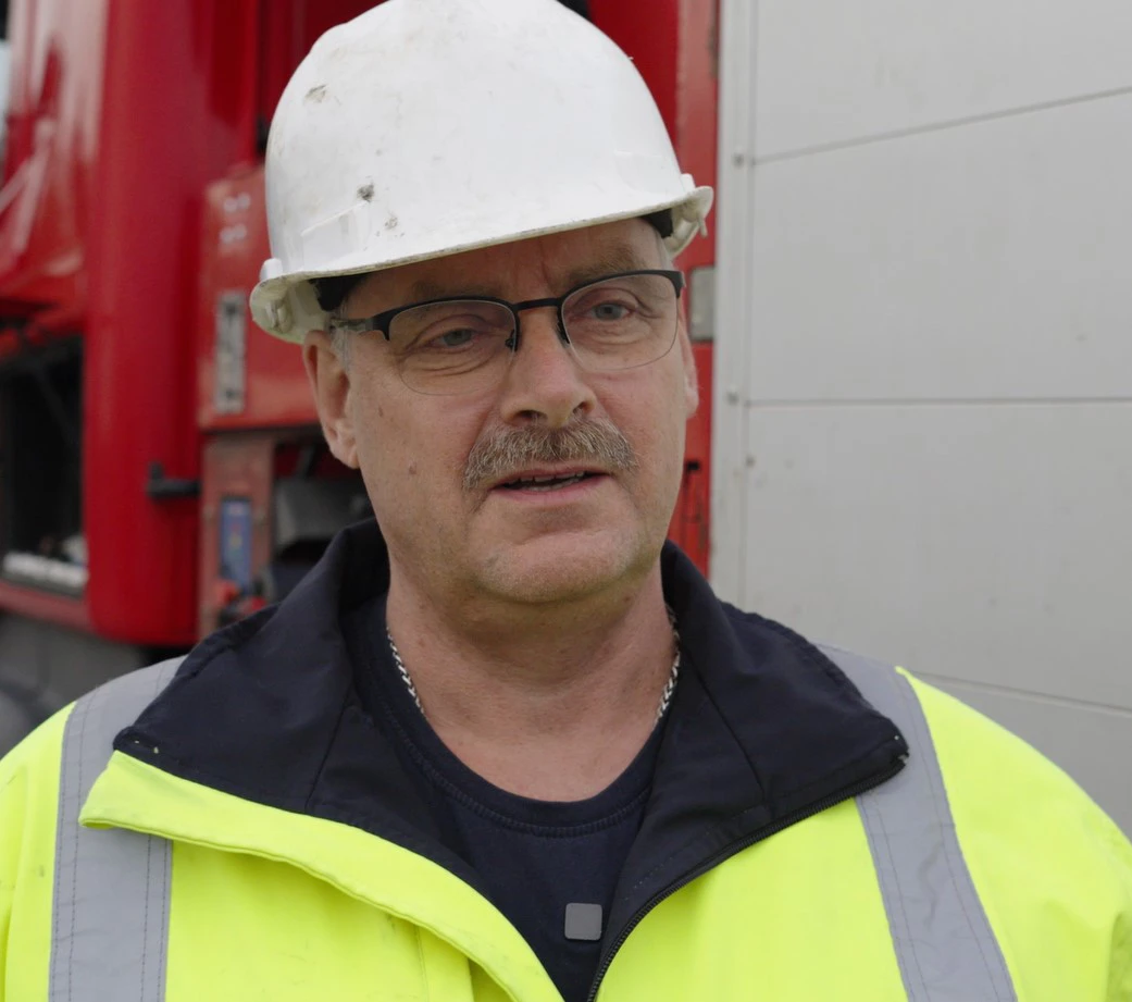 Portræt af mand med hjelm og vest, der fortæller om en arbejdsulykke.