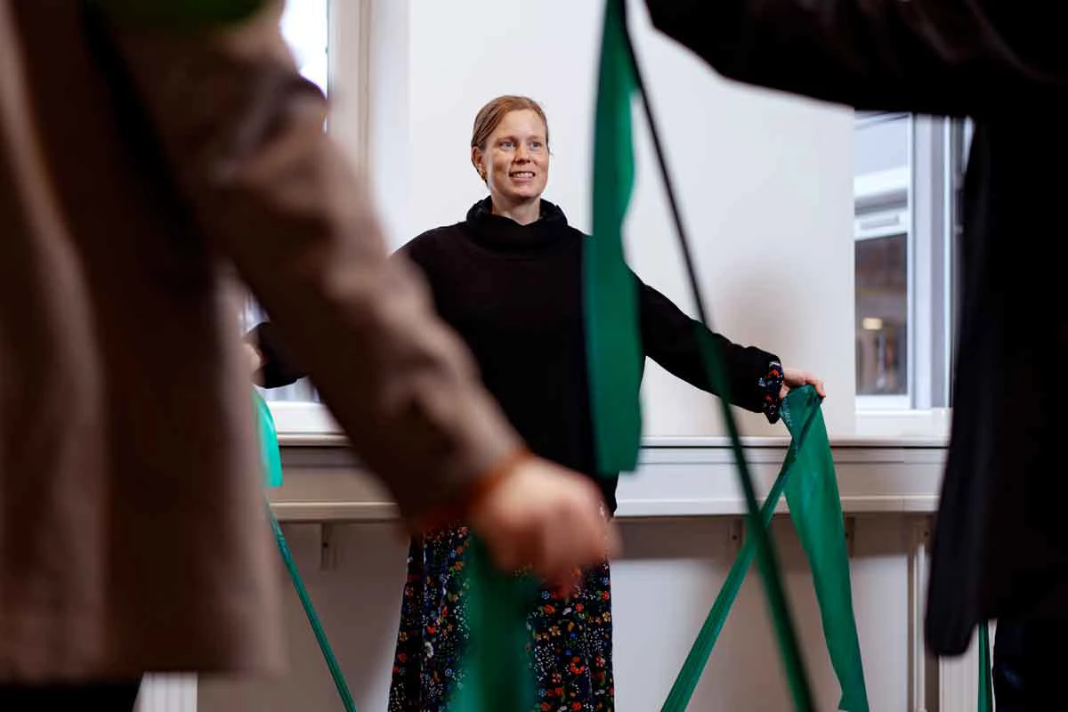 Medarbejdere står og strækker ud med elastikker