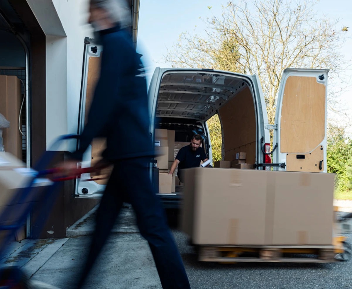 chauffør afleverer pakker på rullevogn