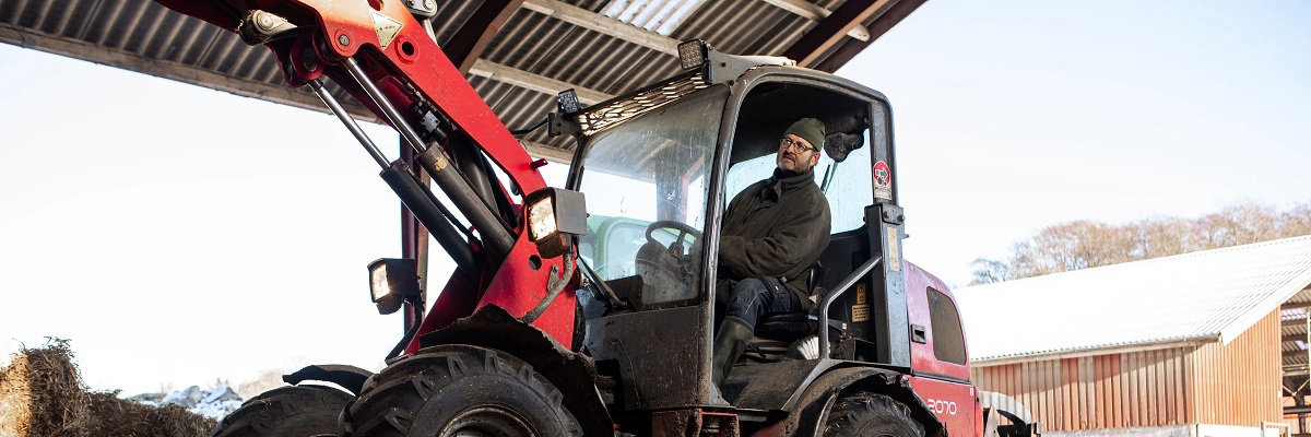 Landmand læsser hø med gaffeltruck