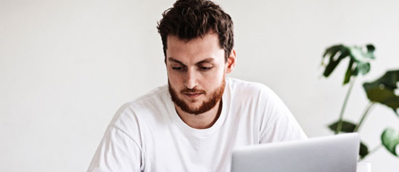 Mand sidder foran laptop