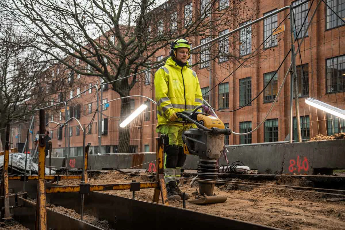 Brolægger betjener en pladevibrator