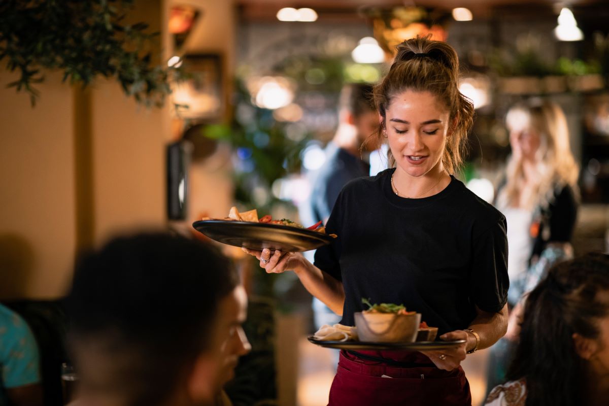 Ung kvinde der arbejder i restaurationsbranchen