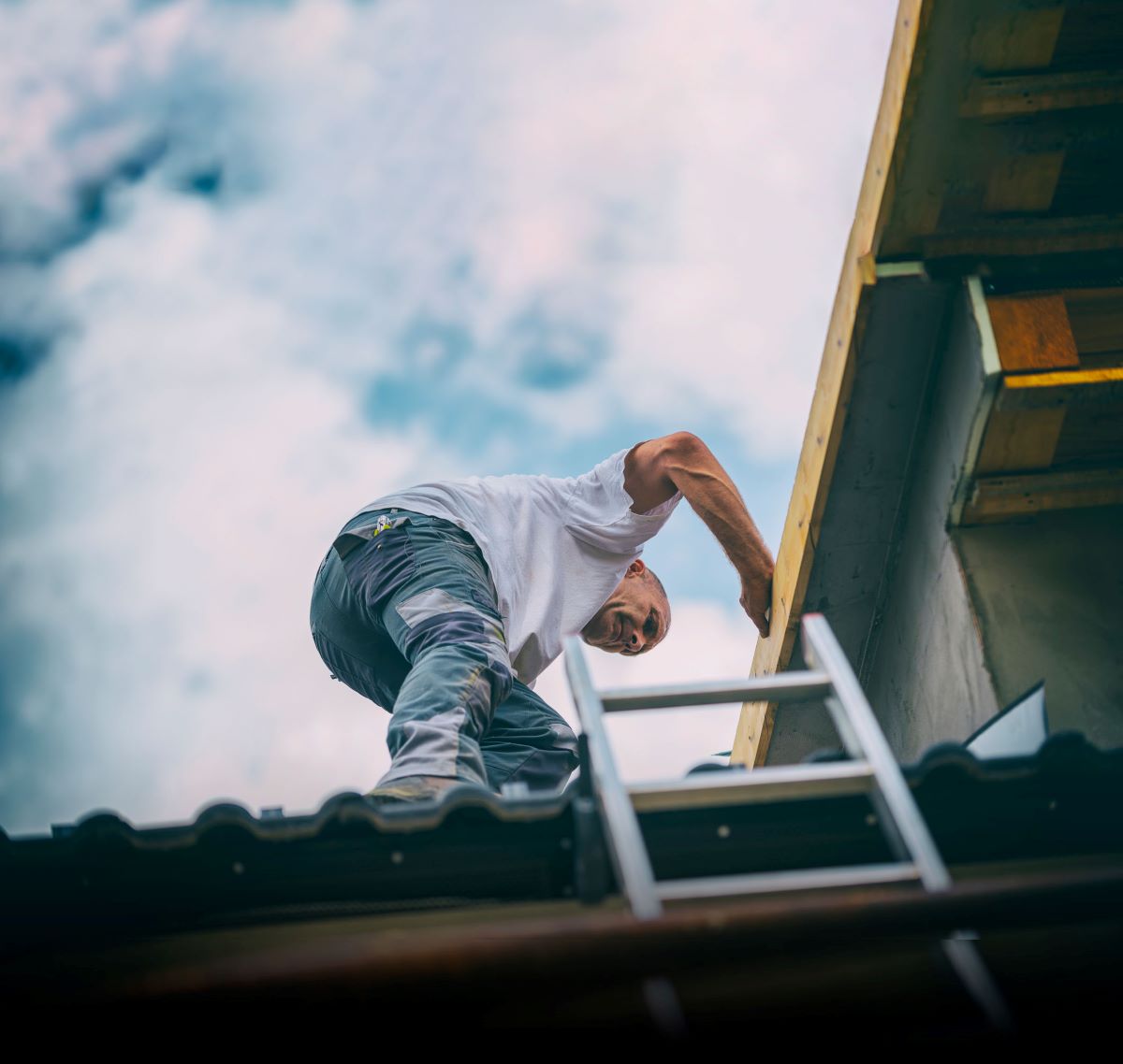 Håndværker er på vej ned fra tag ved hjælp af stige
