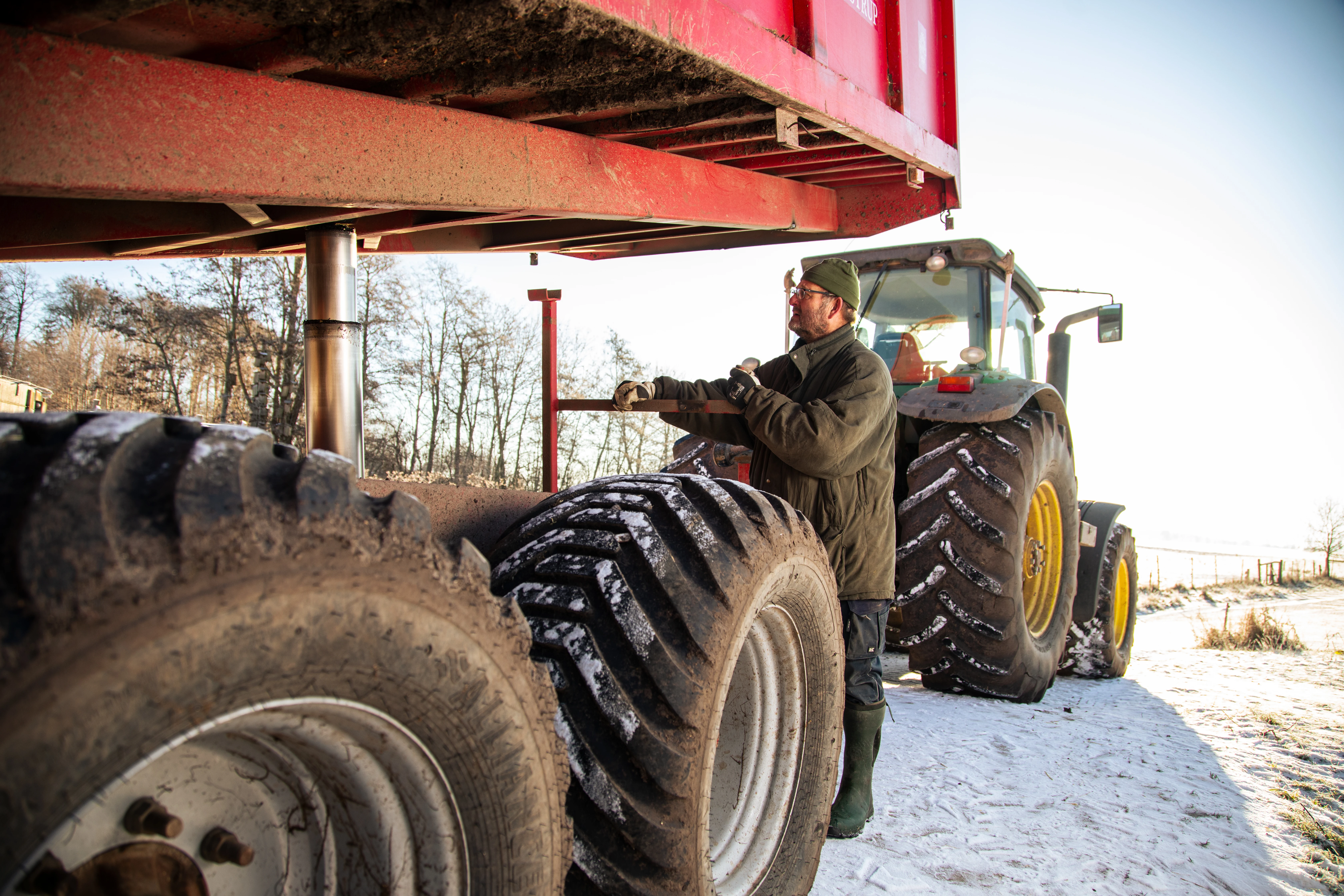 Mand arbejder på anhænger til traktor