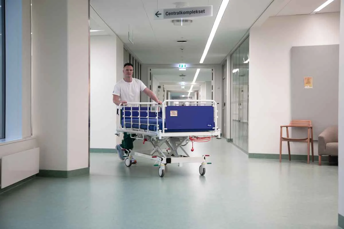 Portør er ved at flytte en hospitalsseng.