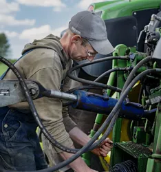 Landmand reparerer maskine