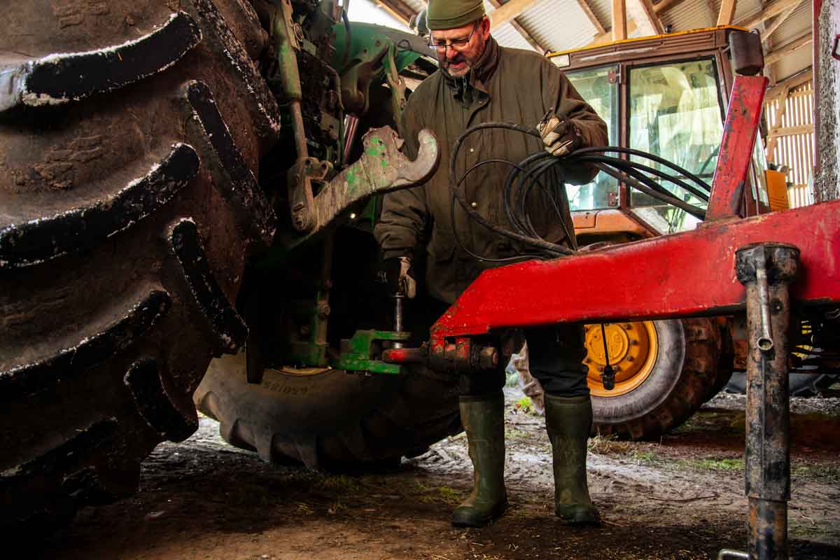 En landmand ordner noget på sin traktor.