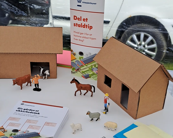 Arbejdstilsynets bord til landbrugsmesse med teksten "Del et staldtip"