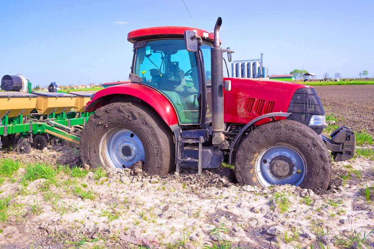 Traktor der kører i meget mudret jord