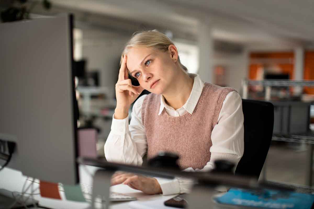 Kvinde tænker ved computer