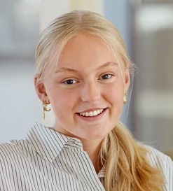 Billede tæt på af pige, der smiler til kameraet.