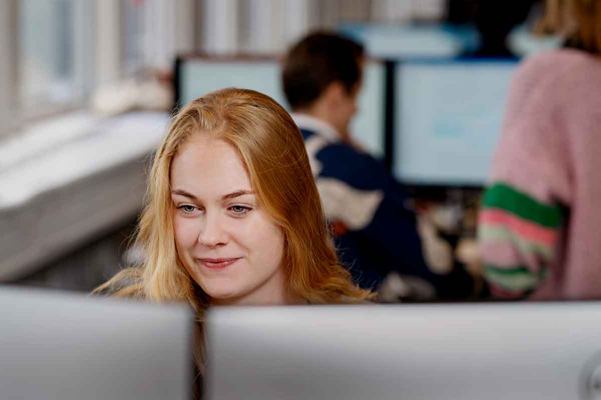 Kvinde sidder foran en computerskærm.