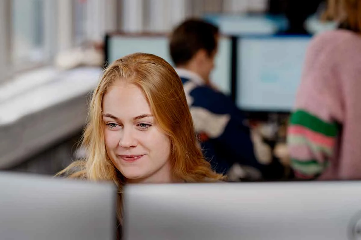 Kvinde sidder foran en computerskærm.