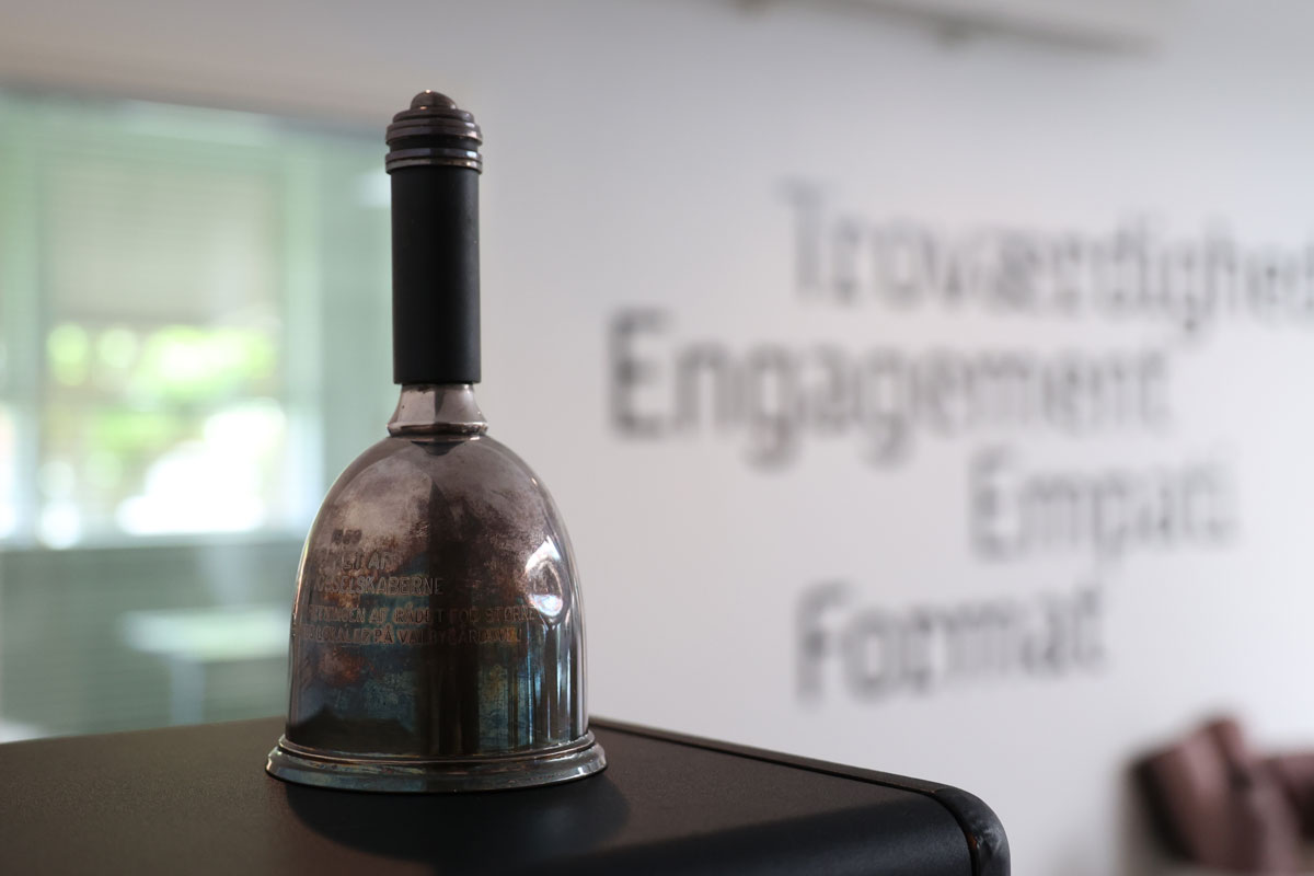 Klokke står på et bord med hvid baggrund. 