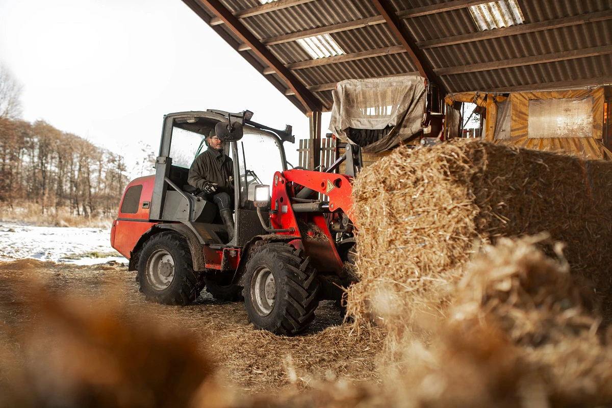 Traktor flytter halmballer