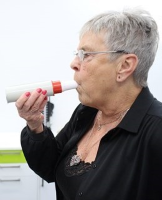 Foto af patient der puster i en peak-flow måler