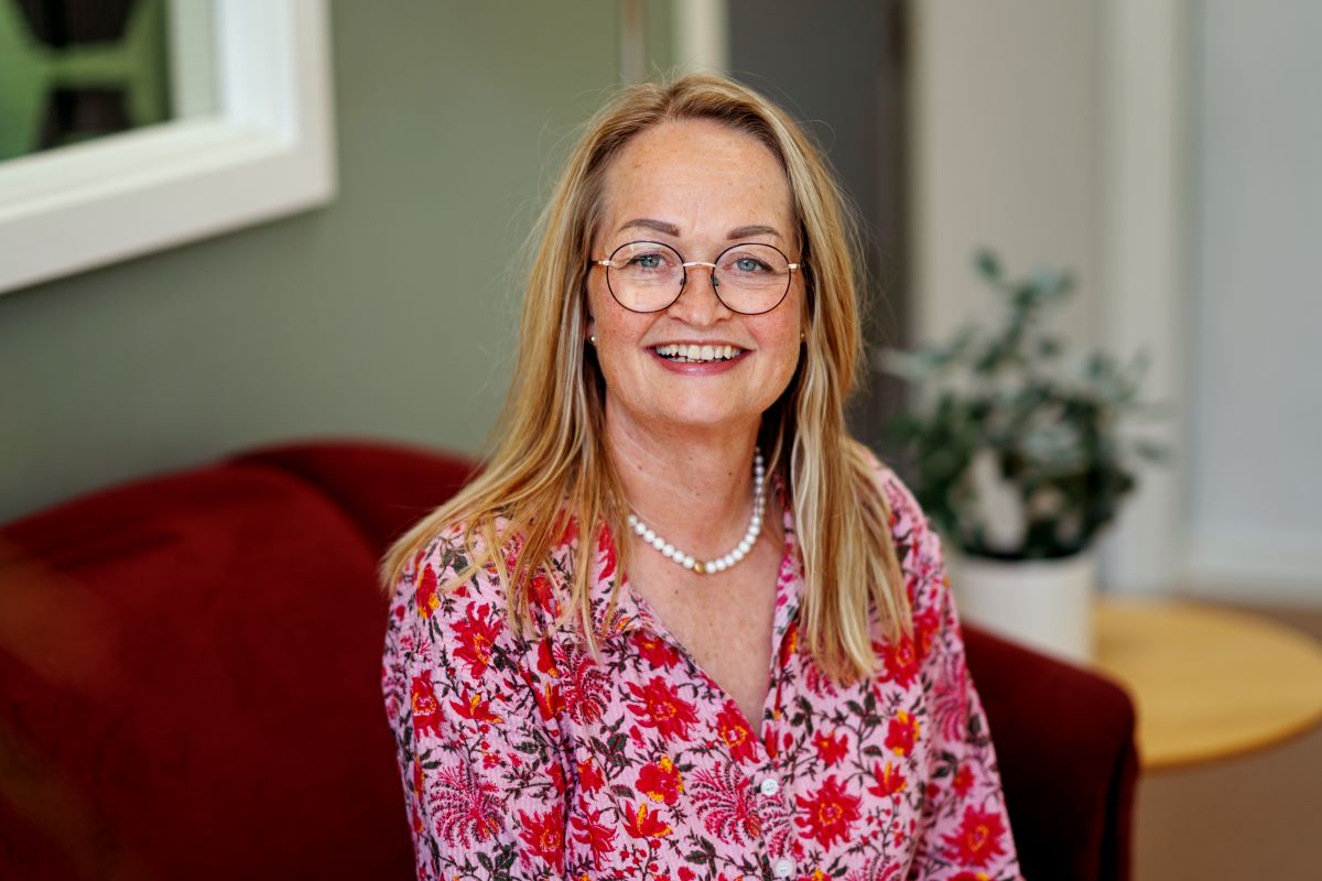 Portræt af kvindelig leder på plejehjemmet, der smiler til kameraet.