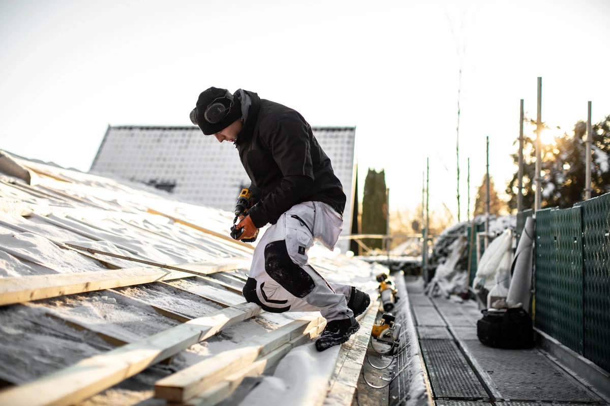 Mand arbejder på tag