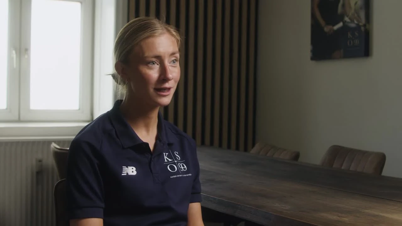 Kvinde sidder ned og snakker. 