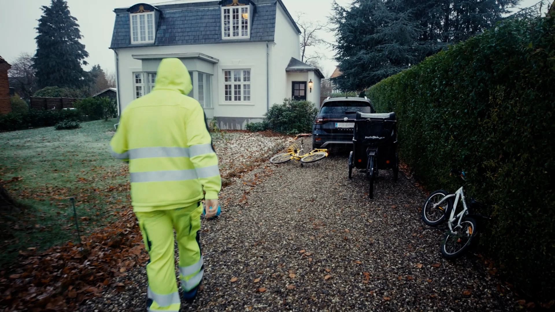 Renovationsmedarbejder på vej til at hente skraldespande hos borger